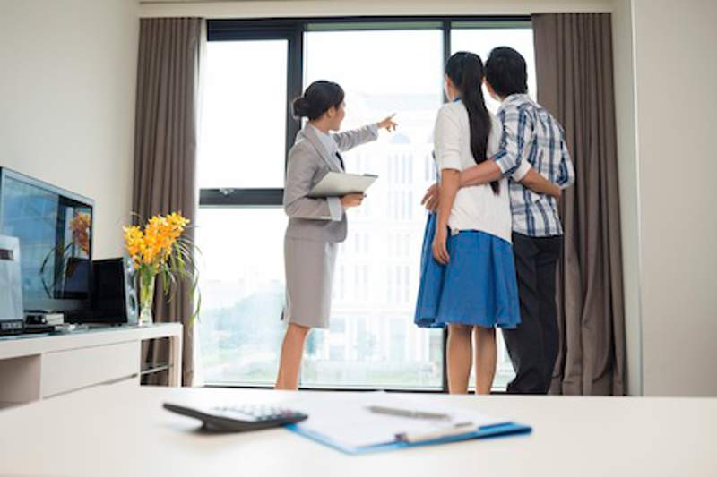 Estate broker showing married couple the view from the apartment window foto : Bonnie Spindler